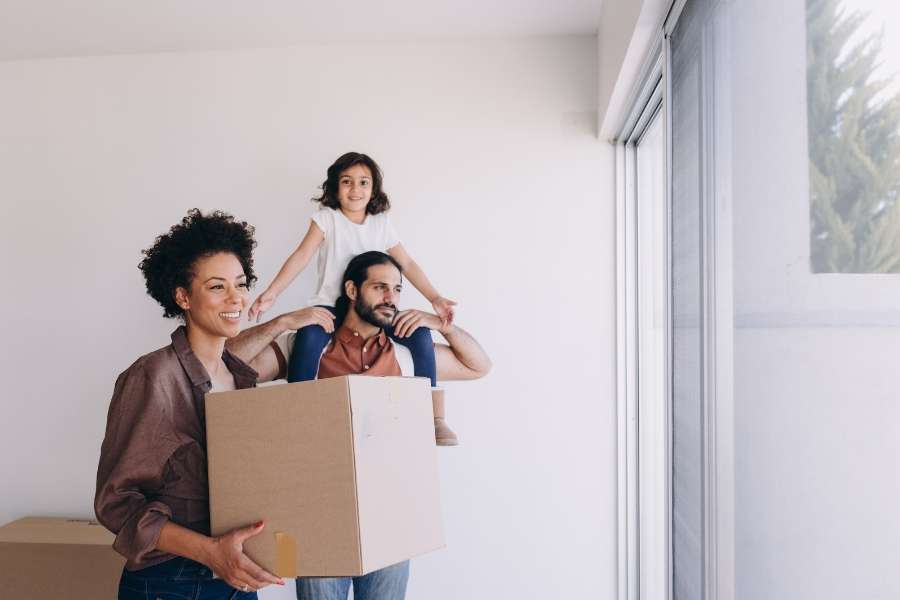 Une famille souriante découvre son nouveau logement grâce au parrainage déménagement.
