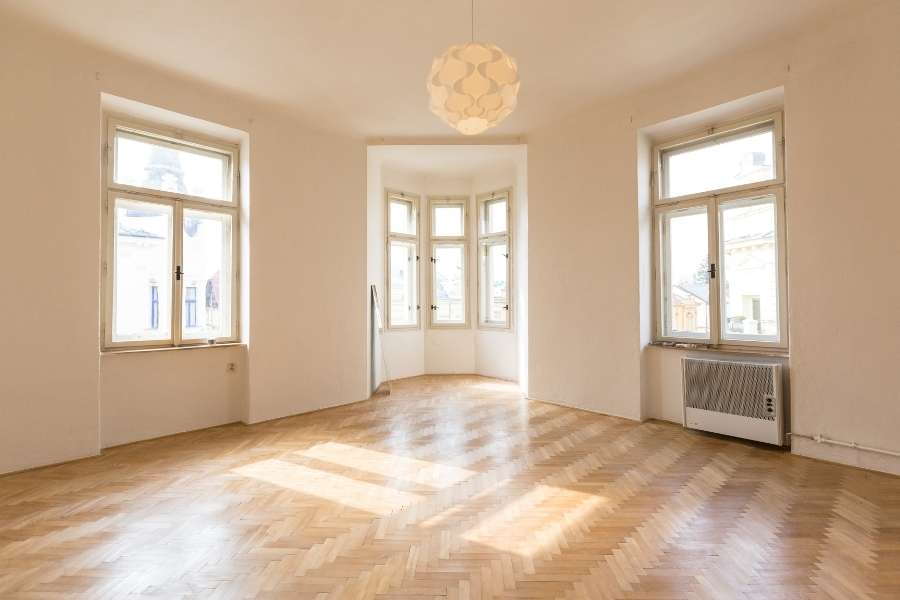 Un appartement spacieux et vide avec du parquet en bois, idéal pour maximiser son rendement locatif après rénovation.