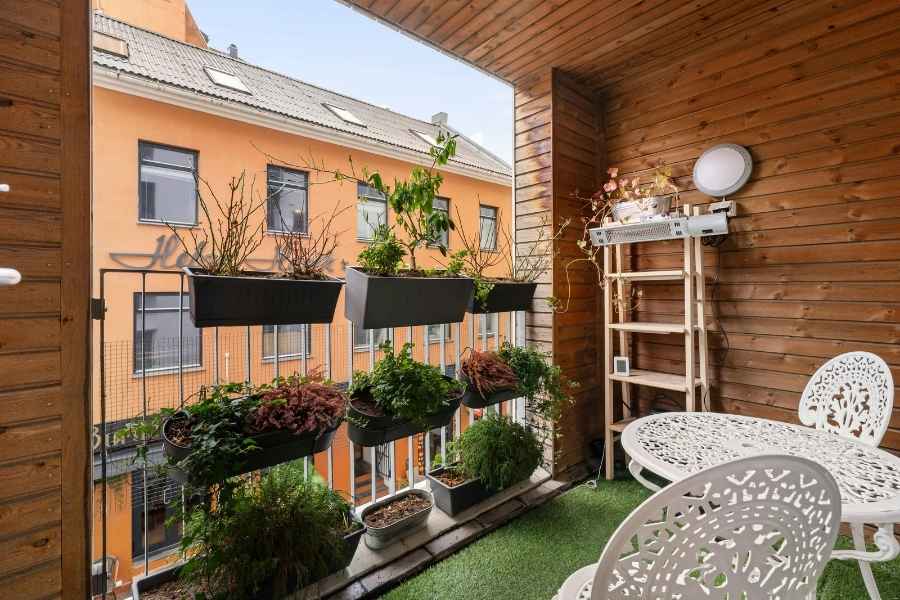 Un balcon en bois chaleureux rempli de jardinières pour cultiver des aromates en ville.